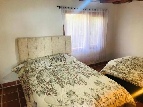 a bedroom with a bed and a window at Cabaña de descanso en la montaña in Mongua