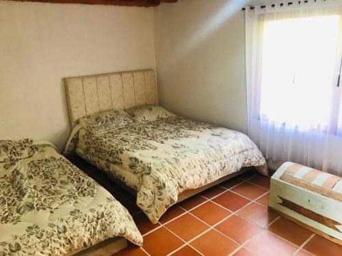 1 Schlafzimmer mit 2 Betten und einem Fenster in der Unterkunft Cabaña de descanso en la montaña in Mongua