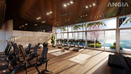 un gimnasio con filas de equipos de ejercicio en un edificio en The Song Vung Tau Near Beach by Hoang Gia en Vung Tau