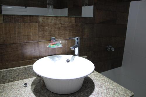 y baño con bañera blanca y lavamanos. en Apartamento 80 O´H Aparthotel., en Ciudad del Este