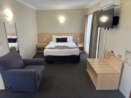 a hotel room with a bed and a couch at City Centre Motel Kempsey in Kempsey