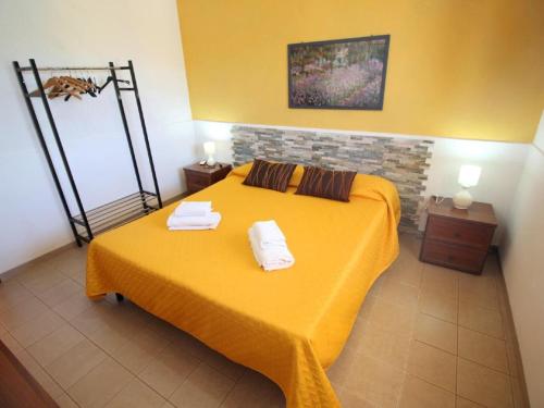 a bedroom with a yellow bed with towels on it at Viila near Syracuse in Siracusa in Siracusa