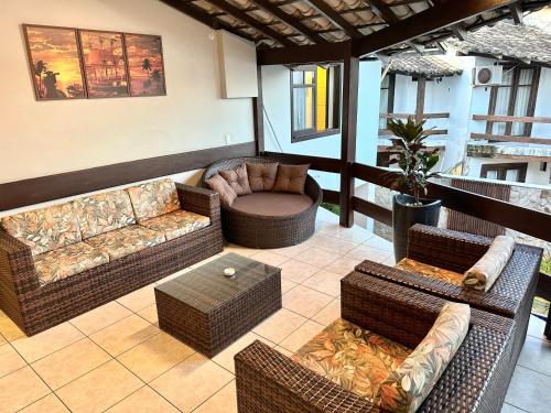 uma sala de estar com mobiliário em vime e uma mesa em Hotel Bem Brasil em Porto Seguro