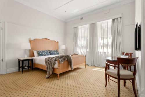 a bedroom with a bed and a table and a chair at The Robertson Hotel in Robertson
