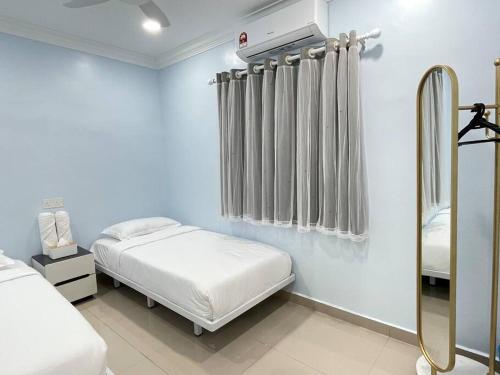 a bedroom with two beds and a shower in it at Happi Homestay@Taman Saga in Bentong