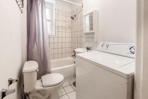 een witte badkamer met een toilet en een wastafel bij 3 bedroom apartment in Verdun in Montreal