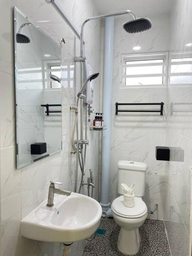 a white bathroom with a toilet and a sink at Happi Homestay@Taman Saga in Bentong