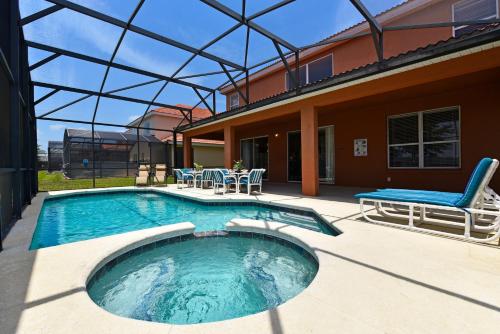 una piscina con una silla y una casa en Family Friendly Home, South-facing Pool,Spa, Gated Resort near Disney -928, en Davenport