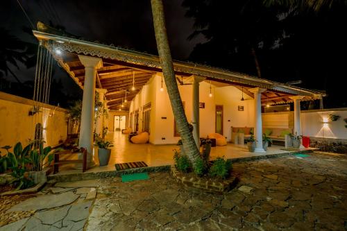 a porch of a house with a palm tree at Sixth Sense Hostel in Galle