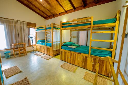 a bedroom with three bunk beds and a desk at Sixth Sense Hostel in Galle