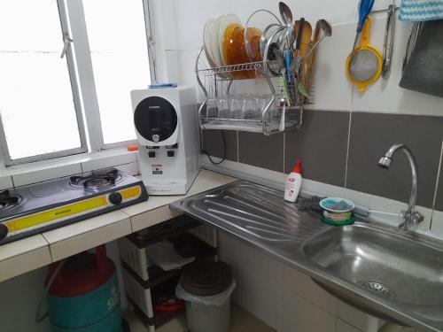 um balcão de cozinha com um lavatório e uma janela e um balcão em Thea's Homestay em Tanah Rata
