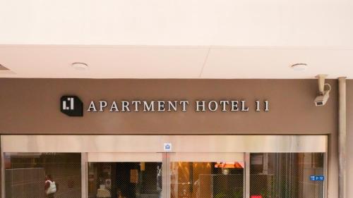a building with a sign for an apartment hotel at Apartment Hotel 11 Shinsaibashi 2 in Osaka