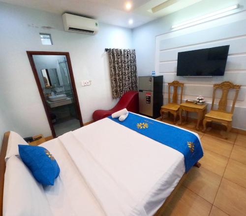a bedroom with a large bed and a television at COZY Hotel HCM in Ho Chi Minh City