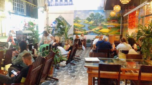eine Gruppe von Personen, die in einem Restaurant sitzen in der Unterkunft Truong Son Luxury Homestay in Ninh Bình