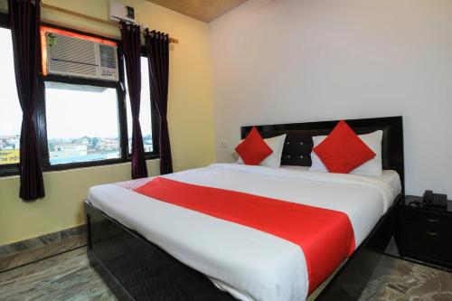 een slaapkamer met een groot bed met rode kussens bij Hotel Mehraz Residency in Haldwani