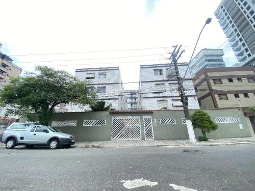 a car parked on the side of a street with buildings at Pé na areia canto do forte II in Praia Grande