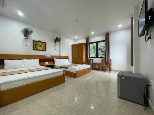 a bedroom with two beds and a tv in it at Galaxy Home - Hotel Sky view in Cat Ba