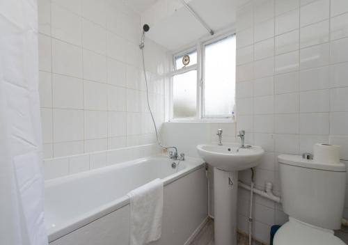biała łazienka z toaletą i umywalką w obiekcie Prime London Location 3-Bed Flat w Londynie