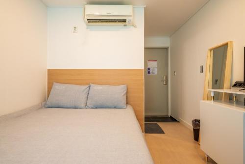 a small room with a bed and a heater at Parkavenue Guesthouse in Seoul