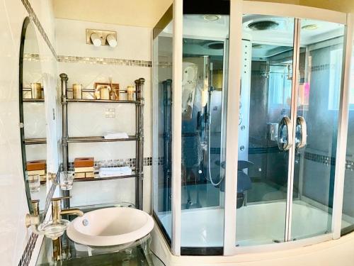 Green BayにあるCasa Amarillaのガラスのシャワーと洗面台を備えたバスルーム