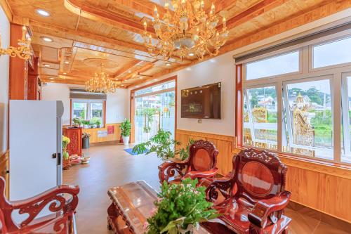 uma sala de estar com cadeiras e um lustre em Ngọc Sang 2 Hotel em Xuan An