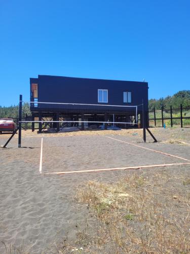 a building with a basketball court in front of it at Casa Bosques & Mar in Pelluhue