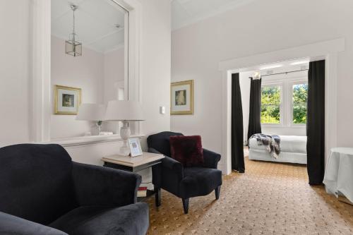 a living room with a couch and chairs and a bed at The Robertson Hotel in Robertson