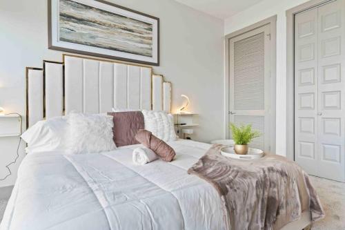 Un dormitorio blanco con una cama grande con una planta. en NEW! ChateauOasis PenthouseViews KingBed FreePark en Atlanta