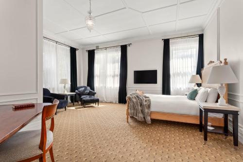 a bedroom with a bed and a desk and a tv at The Robertson Hotel in Robertson