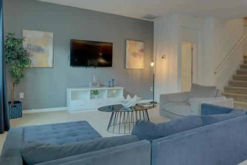 a living room with two blue couches and a table at Summer Escape - Spacious 8BR Home with Private Pool! in Kissimmee