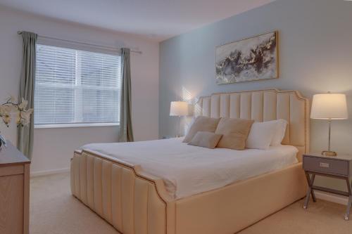 a bedroom with a large bed with white sheets and a window at Private Luxury Villa, Theme PlayRoom, Heated pool in Kissimmee