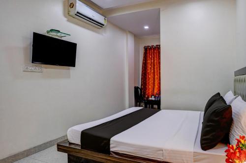 Om Sai Lodge Hotel tesisinde bir odada yatak veya yataklar
