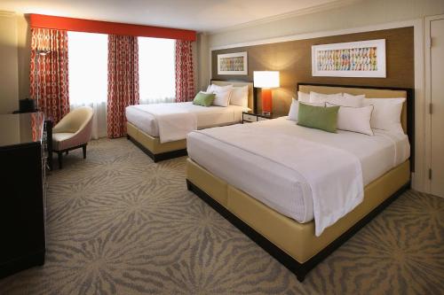 um quarto de hotel com duas camas e uma cadeira em Cozy Unit at Resort Casino Hotel Atlantic City em Atlantic City