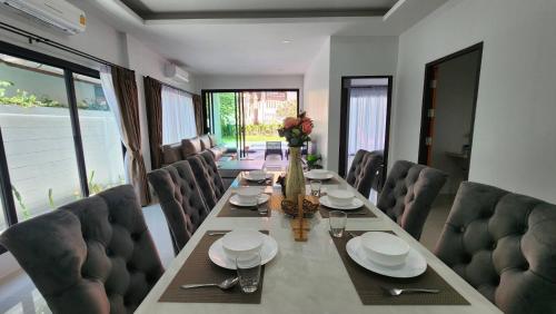 un comedor con una mesa larga y sillas en PoolVilla 234 Patong, en Patong Beach