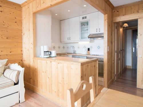 une cuisine avec des armoires blanches et un comptoir en bois dans l'établissement 2 pièces sud à 500 m des pistes avec Wifi et animaux admis - FR-1-449-53, à Tignes