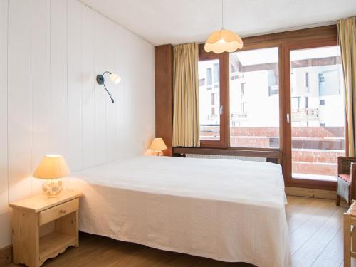 une chambre avec un grand lit blanc et une fenêtre dans l'établissement Appartement spacieux 3 pièces, Tignes, proche des pistes - FR-1-449-59, à Tignes