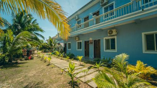 瓜隆島的住宿－Koh Rong 71 Guesthouse，一座棕榈树的蓝色房子