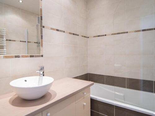 La salle de bains est pourvue d'un lavabo blanc et d'une baignoire. dans l'établissement 2 pièces sud/ouest proche pistes, WiFi, animaux admis - FR-1-449-118, à Tignes