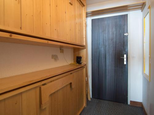 une cuisine avec des placards en bois et une porte noire dans l'établissement Studio cosy avec WiFi gratuit à 500m des pistes, Tignes - FR-1-449-138, à Tignes