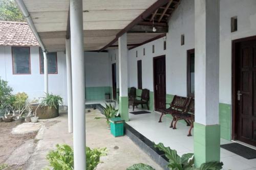 a front porch of a house with chairs at Homestay Wijaya Mulya in Magelang