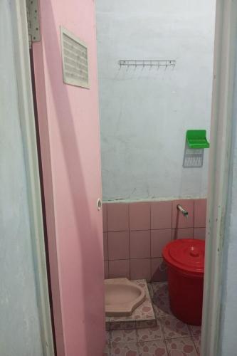 ein Badezimmer mit einem roten WC in einer rosa Kabine in der Unterkunft Homestay Wijaya Mulya in Magelang