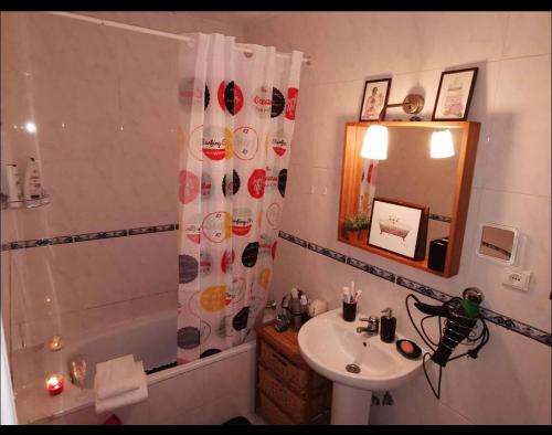 y baño con cortina de ducha y lavamanos. en Parque güell, en Barcelona