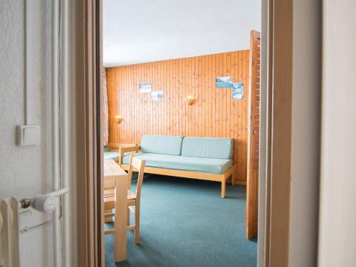 une chambre avec un canapé bleu et une table dans l'établissement 2 pièces Sud à 500m des pistes, Wifi, TV - FR-1-449-157, à Tignes