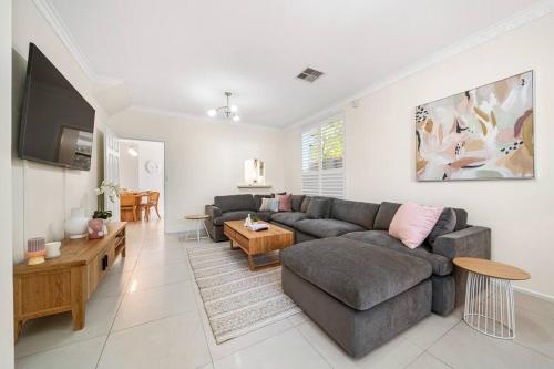 a living room with a couch and a table at Petal and Bloom - 3BR Family CBD in Adelaide