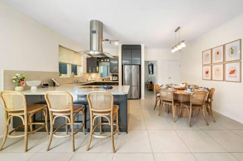 a kitchen and dining room with a table and chairs at Petal and Bloom - 3BR Family CBD in Adelaide