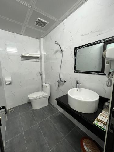 a white bathroom with a sink and a toilet at HOA CƯƠNG HOTEL 2 (HÀ GIANG) in Ha Giang