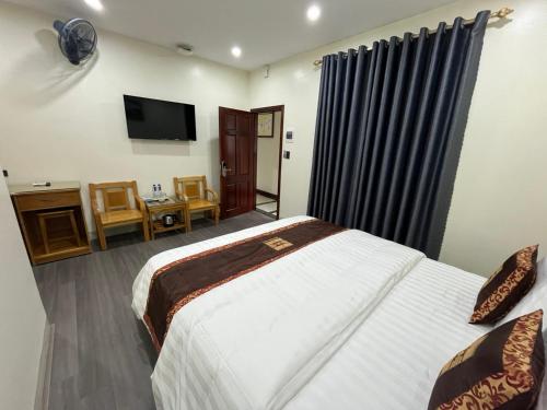 a hotel room with a bed and a television at HOA CƯƠNG HOTEL 2 (HÀ GIANG) in Ha Giang