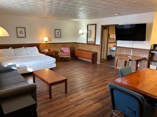 um quarto de hotel com uma cama e uma sala de estar em Valley Inn and Suites em French Lick