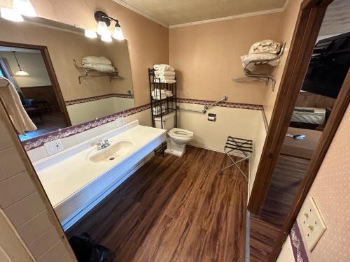 a bathroom with a tub and a toilet and a sink at Valley Inn and Suites in French Lick
