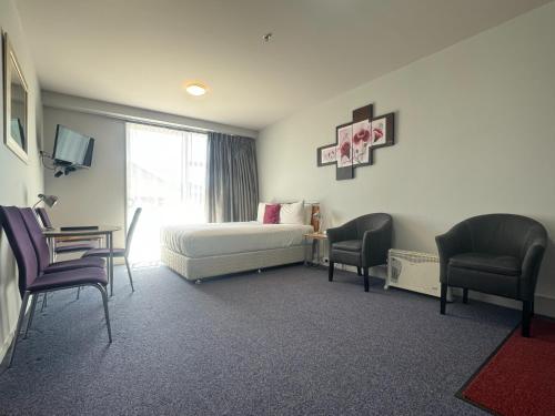 a hotel room with a bed and two chairs at Best Western Wellington in Wellington